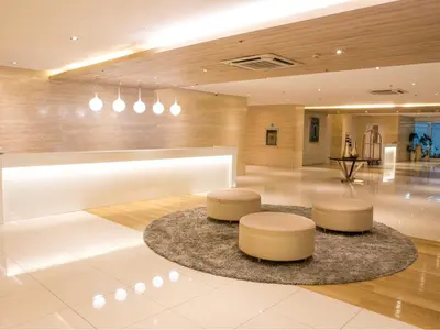a lobby with two circular stools and a table at Hotel101 - Manila in Manila