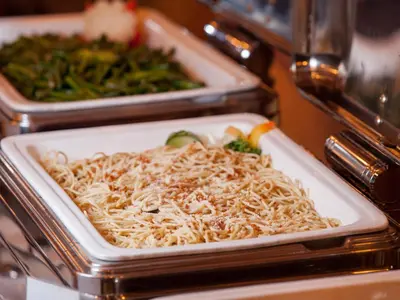 a plate of noodles and vegetables on a table at Hotel101 - Manila in Manila