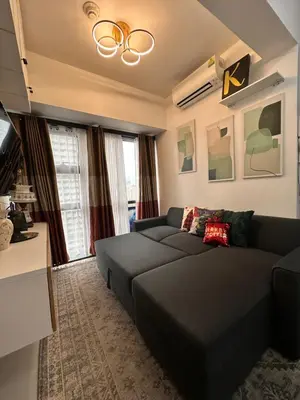 a living room with a couch and a tv at City Escape by Fame in Manila