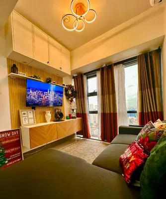 a living room with a couch and a flat screen tv at City Escape by Fame in Manila