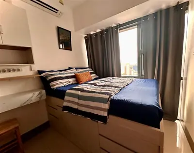 two beds in a small room with a window at City Escape by Fame in Manila