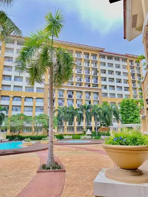 a palm tree in front of a large building at Your Comfort Zone Staycation2 in Manila