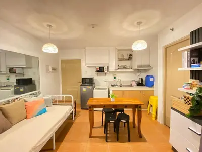 a kitchen and living room with a table and a couch at Your Comfort Zone Staycation2 in Manila
