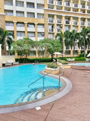 a large swimming pool in front of a building at Your Comfort Zone Staycation2 in Manila