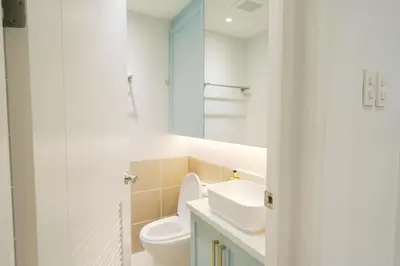 a white bathroom with a toilet and a sink at Mellow Dreams in Manila