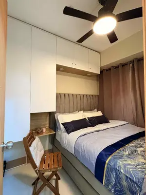 a bedroom with a large bed and a chair at A&P Residence in Manila