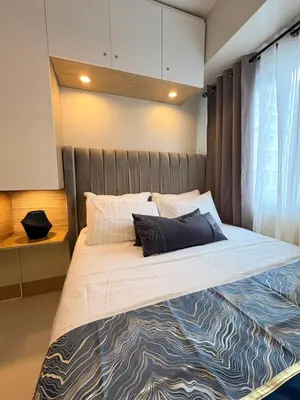 a bedroom with a large bed with a wooden headboard at A&P Residence in Manila