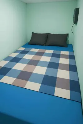 a bed in a room with a checkered floor at Uni Capsules in Manila