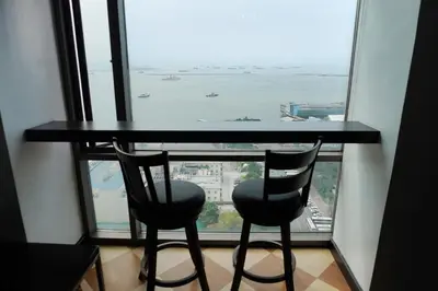 a table and two chairs in front of a window at Eton Baypark Manila Bay in Manila