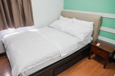 a small bed with white sheets and a night stand at Eton Baypark Manila Bay in Manila
