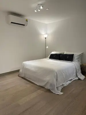 a white bedroom with a large bed with white sheets at New Modern Luxurious 1 Bedroom Condo with WIFI and Netflix in Manila