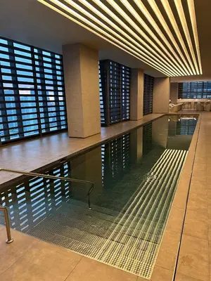 a large swimming pool in a building with windows at New Modern Luxurious 1 Bedroom Condo with WIFI and Netflix in Manila