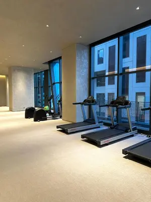 a gym with several treadmills in a building with windows at New Modern Luxurious 1 Bedroom Condo with WIFI and Netflix in Manila