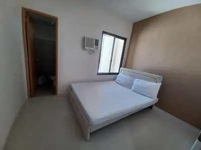 a bedroom with a bed in a room with a window at 88 Residences in Manila
