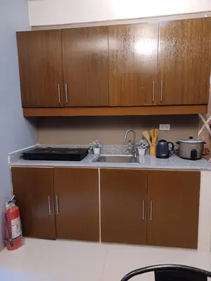 a kitchen with wooden cabinets and a sink at 88 Residences in Manila