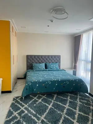 a bedroom with a blue bed and a rug at Robinson's Place Residences, tower 2 in Manila