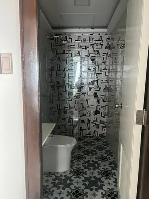 a bathroom with a white toilet and a black and white wall at Robinson's Place Residences, tower 2 in Manila