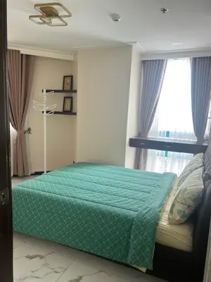a bedroom with a green bed and a window at Robinson's Place Residences, tower 2 in Manila