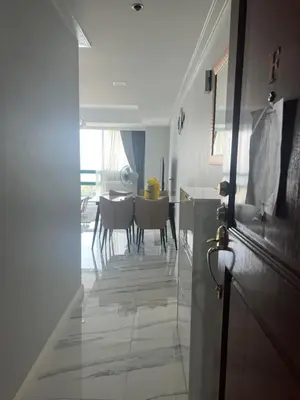 a hallway leading to a dining room with a table at Robinson's place residences tower 2 in Manila