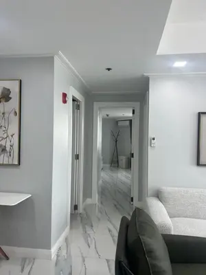 a living room with white walls and a couch at Robinson's place residences tower 2 in Manila