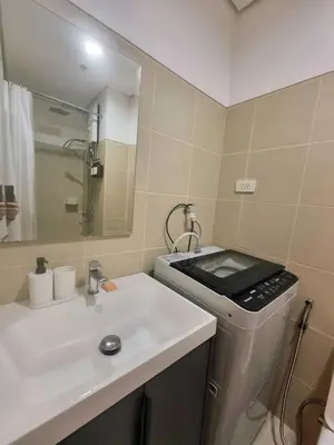 a bathroom with a sink and a washing machine at Luxe Hotel-Style Suite Stay at Ayala Ave in Manila
