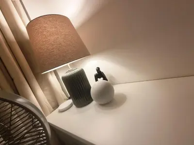 a lamp sitting on a table next to a chair at Luxe Hotel-Style Suite Stay at Ayala Ave in Manila
