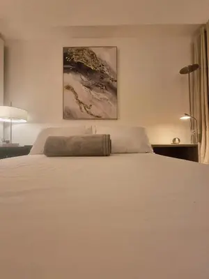 a large white bed in a bedroom with two lamps at Luxe Hotel-Style Suite Stay at Ayala Ave in Manila