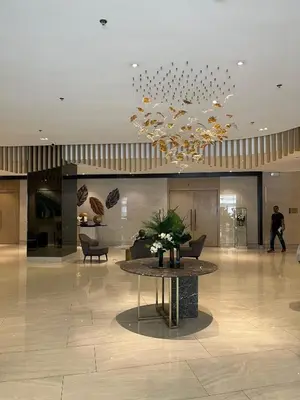 a lobby with a table and a chandelier at Luxe Hotel-Style Suite Stay at Ayala Ave in Manila