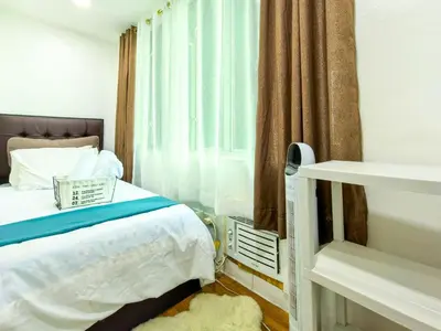 a small bedroom with a bed and a window at CitiClcentro Condo Near everything in Manila
