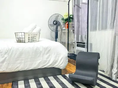 a room with a bed with a fan and a chair at CitiClcentro Condo Near everything in Manila