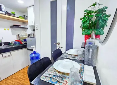 a dining room table with two chairs and a kitchen at CitiClcentro Condo Near everything in Manila