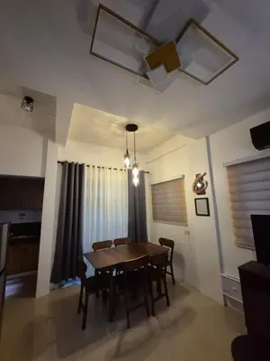 a dining room with a wooden table and chairs at Casa Deña Lawa - Cozy Staycation in Calamba in Calamba
