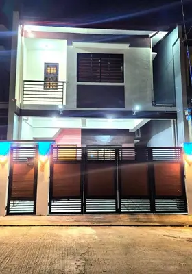 a building with a gate in front of it at night at Casa Deña Lawa - Cozy Staycation in Calamba in Calamba