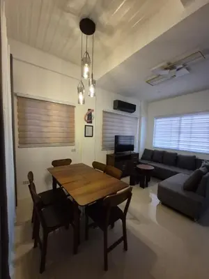 a living room with a table and a couch at Casa Deña Lawa - Cozy Staycation in Calamba in Calamba
