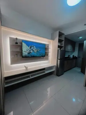 a living room with a flat screen tv on a wall at Affordable Staycation in Pasay near MOA in Manila