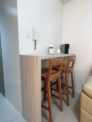 a kitchen with a counter with two chairs and a table at Affordable Staycation in Pasay near MOA in Manila