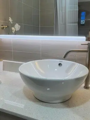 a white bowl sink on a counter in a bathroom at Affordable Staycation in Pasay near MOA in Manila