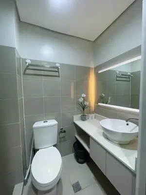 a bathroom with a white toilet and a sink at Affordable Staycation in Pasay near MOA in Manila