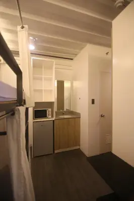 a kitchen with a sink and a stove top oven at Quarto Ph in Manila
