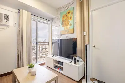 a living room with a tv and a large window at CoZ studio near MAKATI CBD MOA NAIA in Manila
