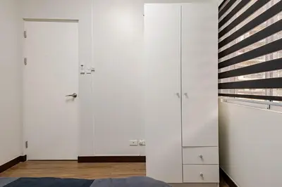 a bedroom with white cabinets and a blue rug at CoZ studio near MAKATI CBD MOA NAIA in Manila