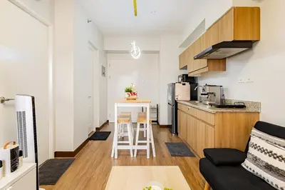 a kitchen and a living room with a table in a room at CoZ studio near MAKATI CBD MOA NAIA in Manila