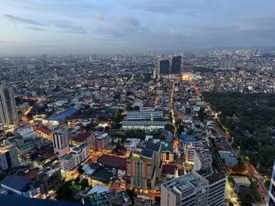 an overhead view of a city at night at Skyline Serenity at 52F & Cozy City Escape Views in Manila