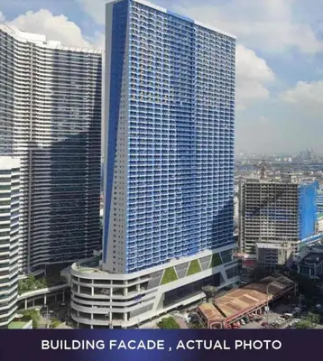 a tall building in a city with many buildings at Skyline Serenity at 52F & Cozy City Escape Views in Manila