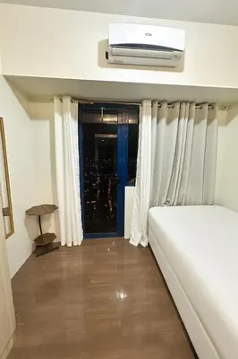 a bedroom with a bed and a window with a tv at Skyline Serenity at 52F & Cozy City Escape Views in Manila