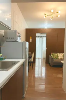 a kitchen and a living room with a couch at Skyline Serenity at 52F & Cozy City Escape Views in Manila