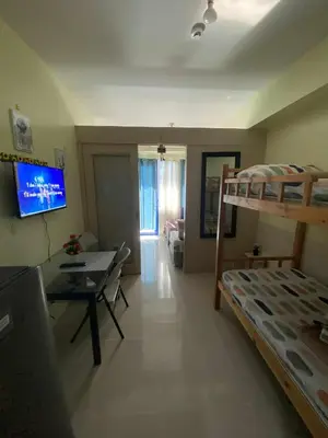 a bedroom with a bunk bed and a living room at Sea Residences Dina in Manila
