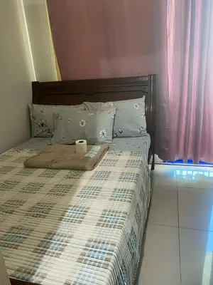 a bed with a blanket and a roll of toilet paper on it at Sea Residences Dina in Manila
