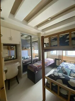 a bedroom with two bunk beds and a desk at 2br Sea Residences pool view dina in Manila
