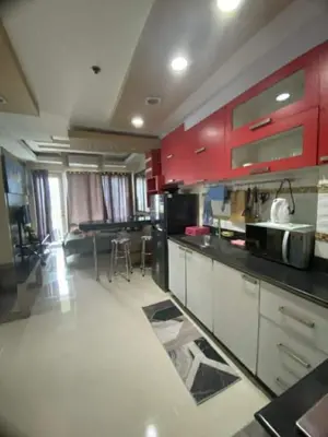 a large kitchen with red cabinets in a room at 2br Sea Residences pool view dina in Manila
